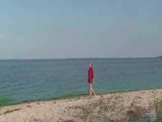 Verlegen naakt meisje op de strand